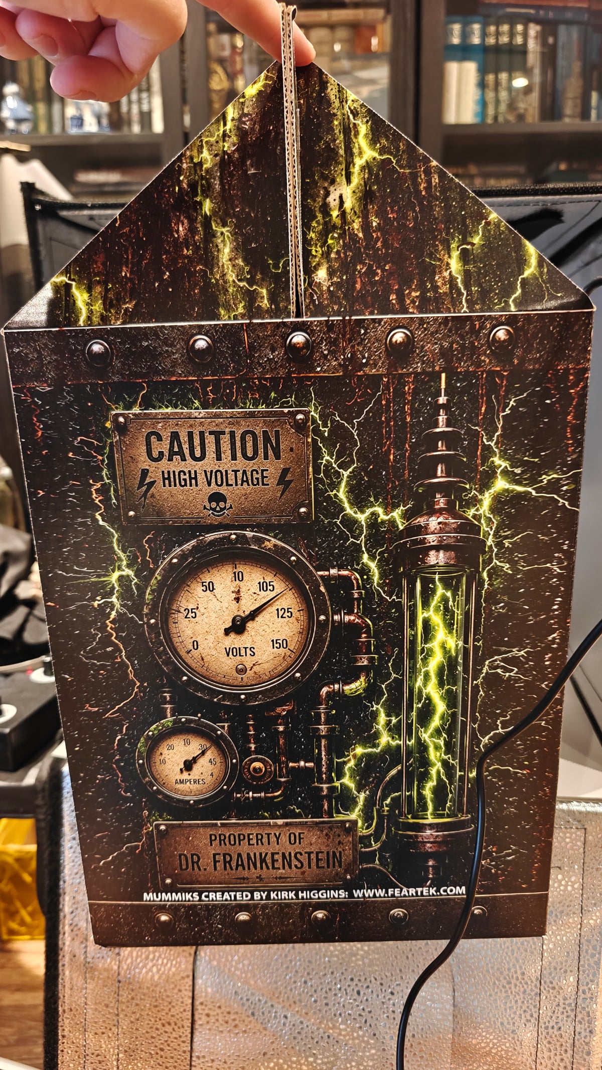 Side of the included Living Mummiks case with printed lightning and Frankenstein laboratory artwork.