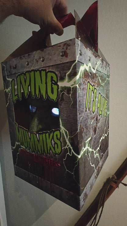 Living Mummiks custom monsters packaging with a hand holding the box.
Frankenstein  Monster 3D printed  Bust with Living Mummiks Display Box  and Digital eyes kit installed. Halloween, Horror Display.